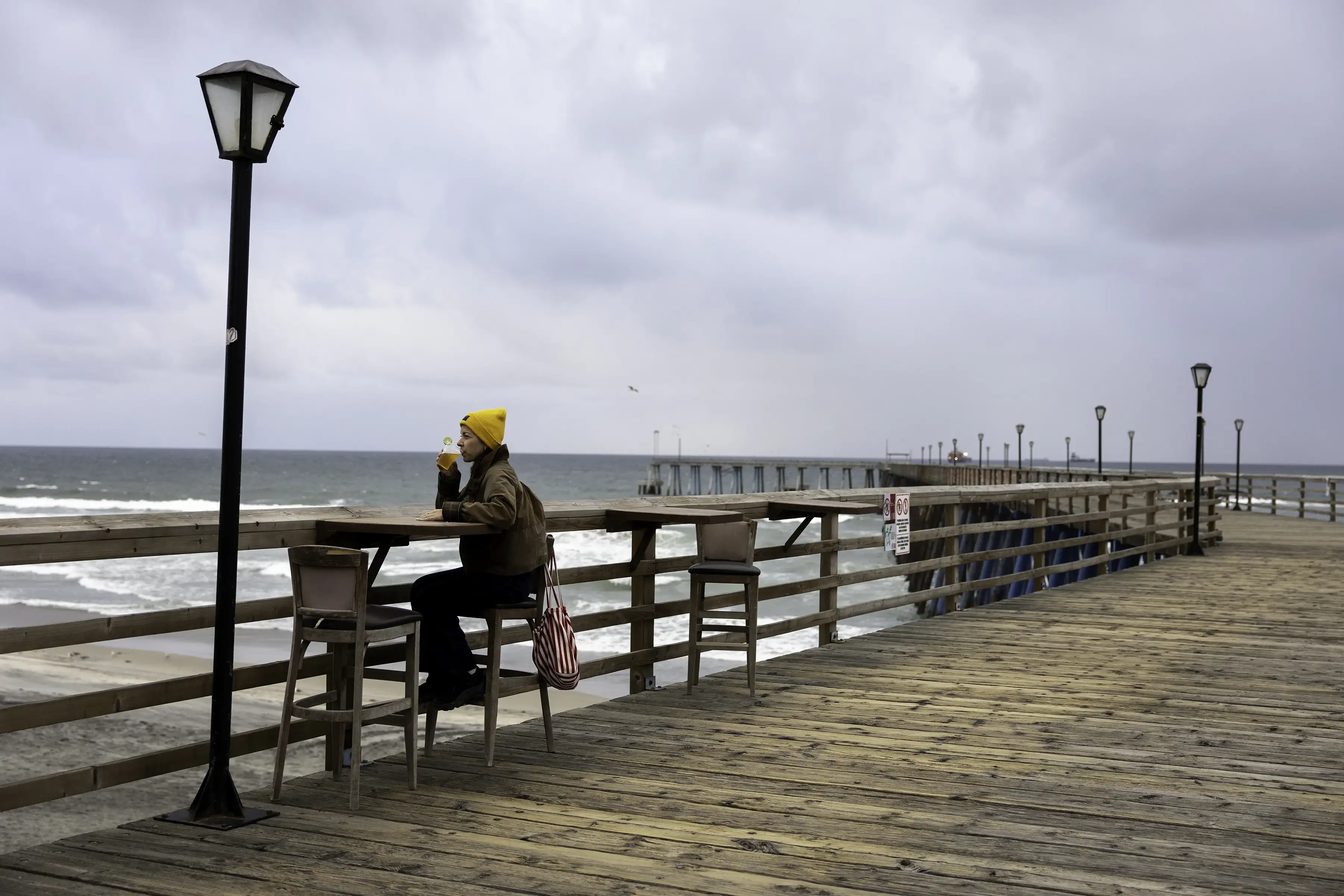 Photograph of a nice woman taking a sip at the pier